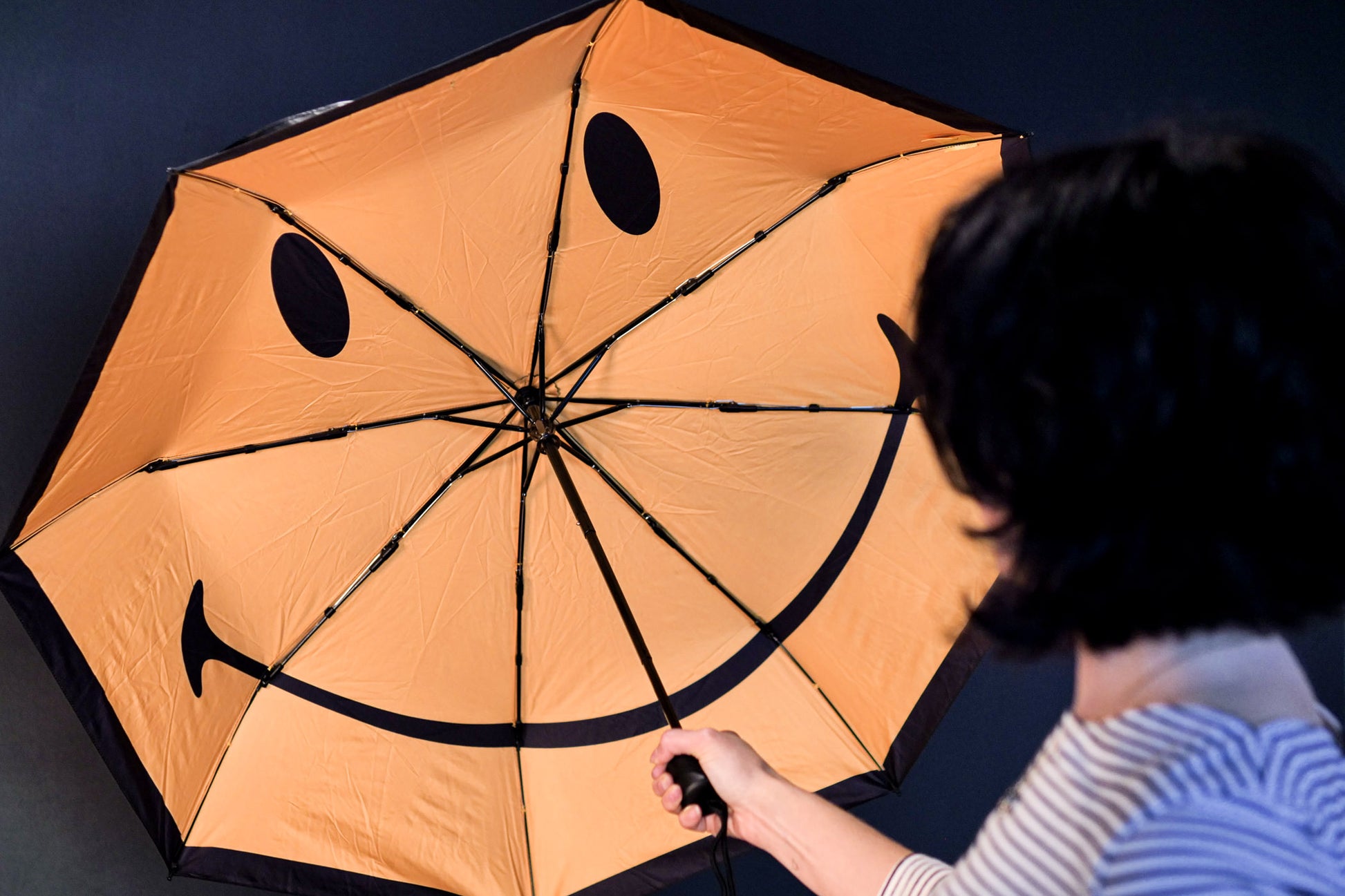 Open umbrella with a yellow smiley face inside