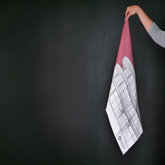 Hand holding a dusty rose tea towel