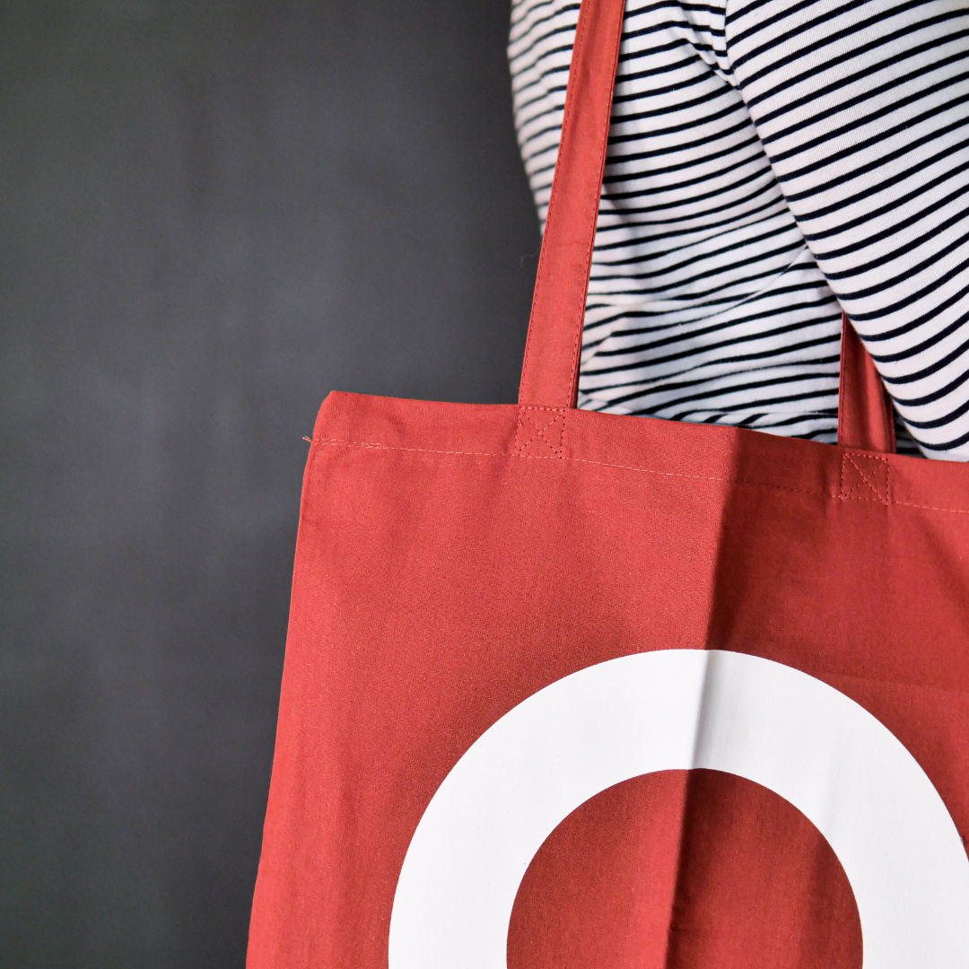 close up of Rust colour tote bag with large white DLWP roundel