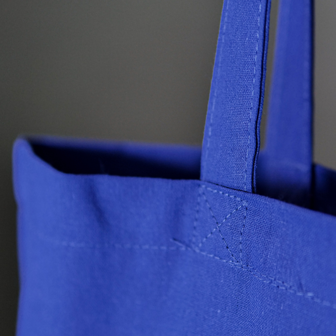 Close up of Canvas shopping bag in royal blue with a large orange DLWP roundel