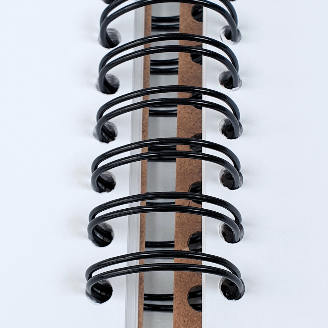 close up of the ring spine of DLWP square sketchbook, brown cover with large black DLWP roundel
