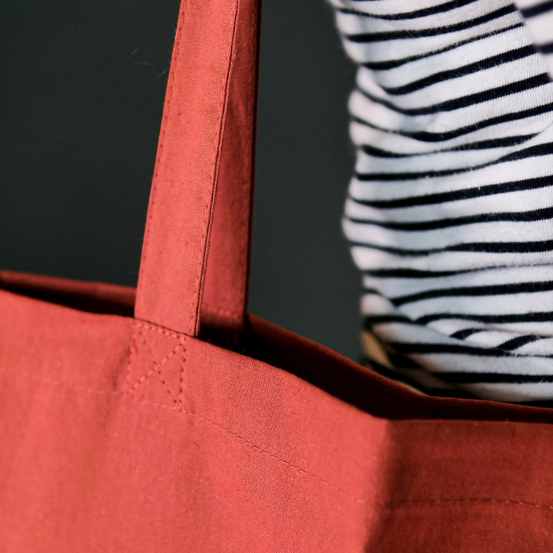 close up of Rust colour tote bag with large white DLWP roundel