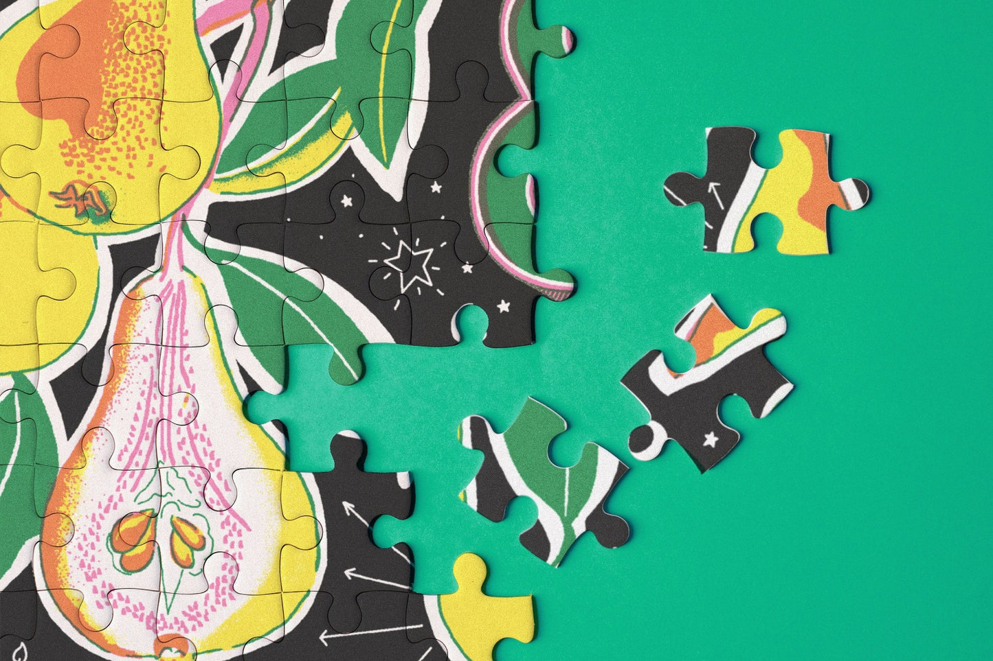 Close up of jigsaw puzzle pieces with botanical illustrations.