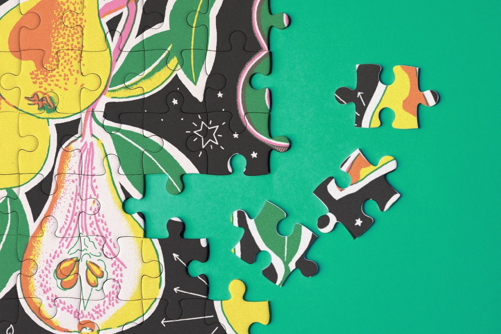 Close up of jigsaw puzzle pieces with botanical illustrations.