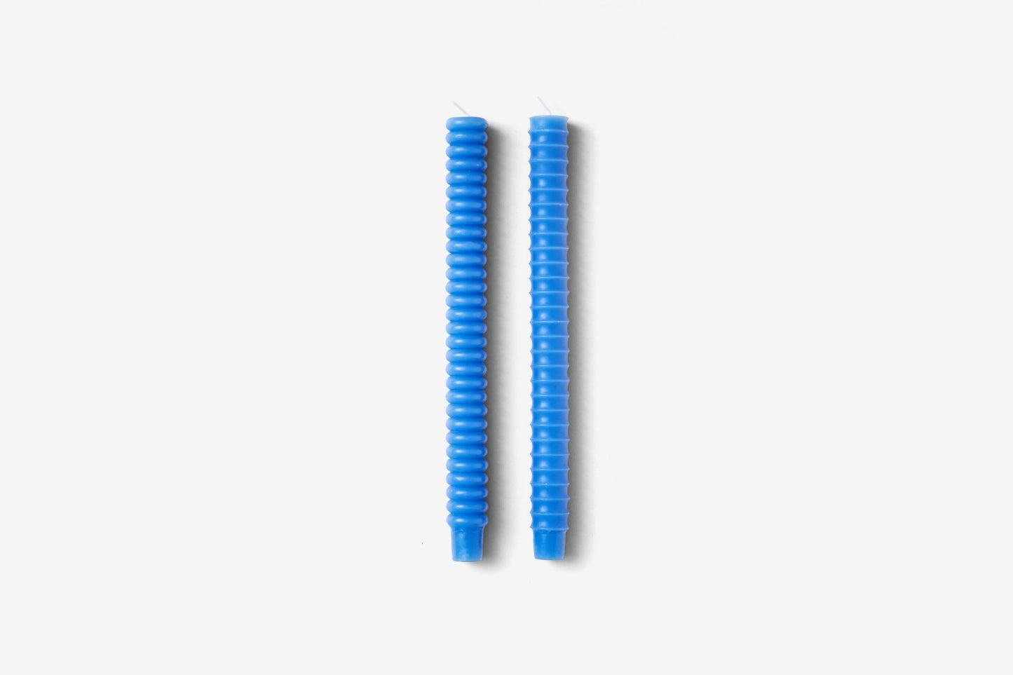 two blue candles - one has convex bumps and the other has concave dips.