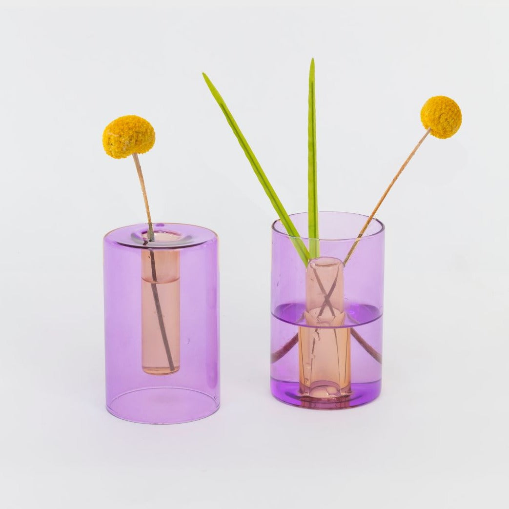 Two lilac and peach reversible vases with yellow flower stems