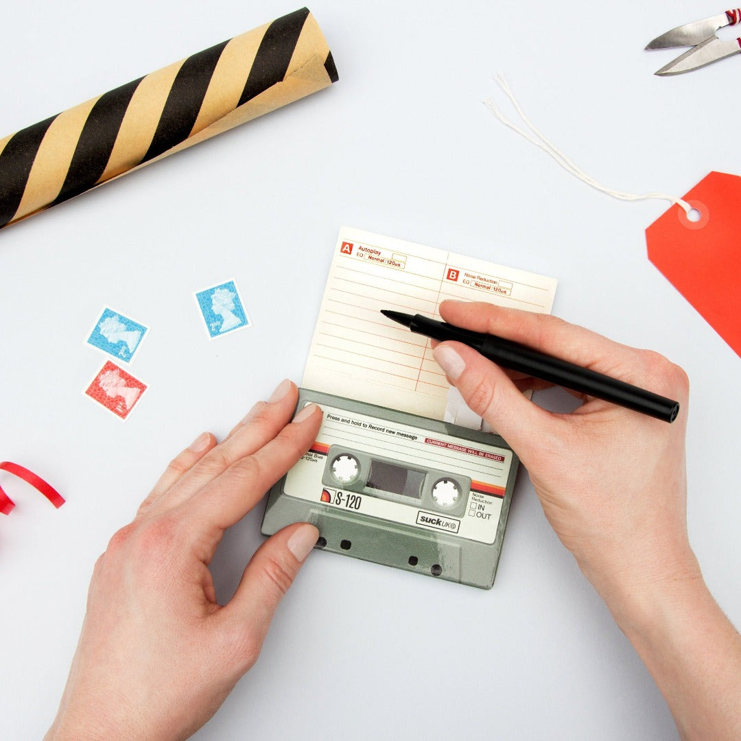 Someone writing in a cassette shaped greetings card