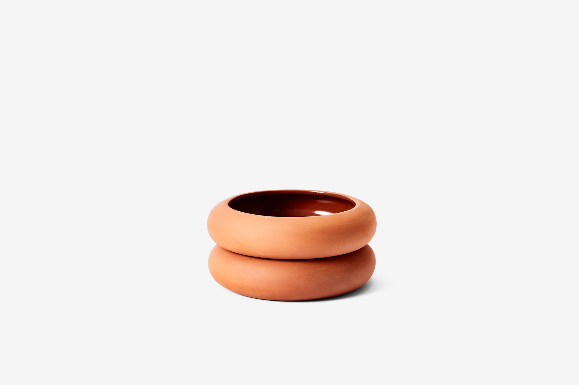 Empty terracotta planter made up of two rounded sections.