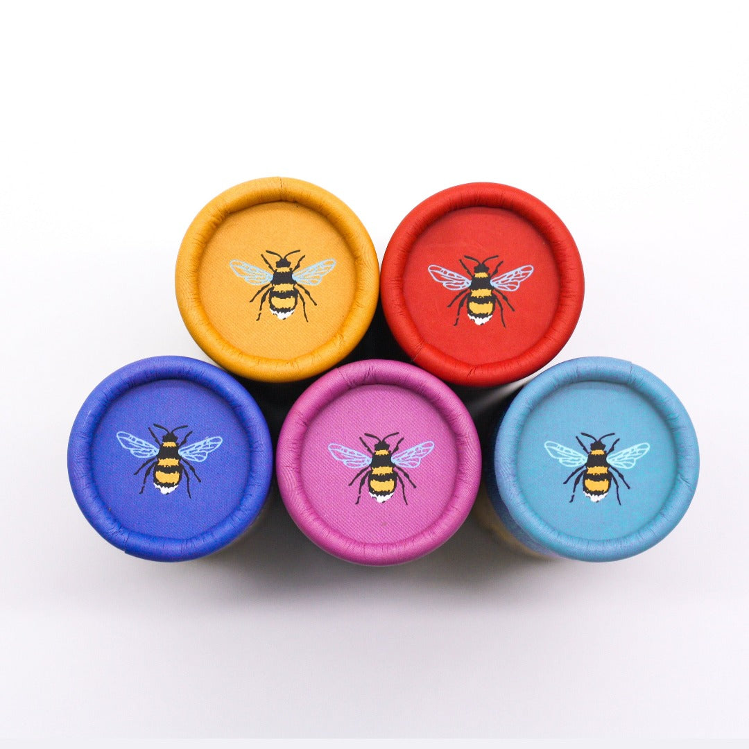 Lids of seedball tubes in different colours with an image of a bee on each
