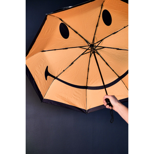 Open umbrella with a yellow Smiley Face inside