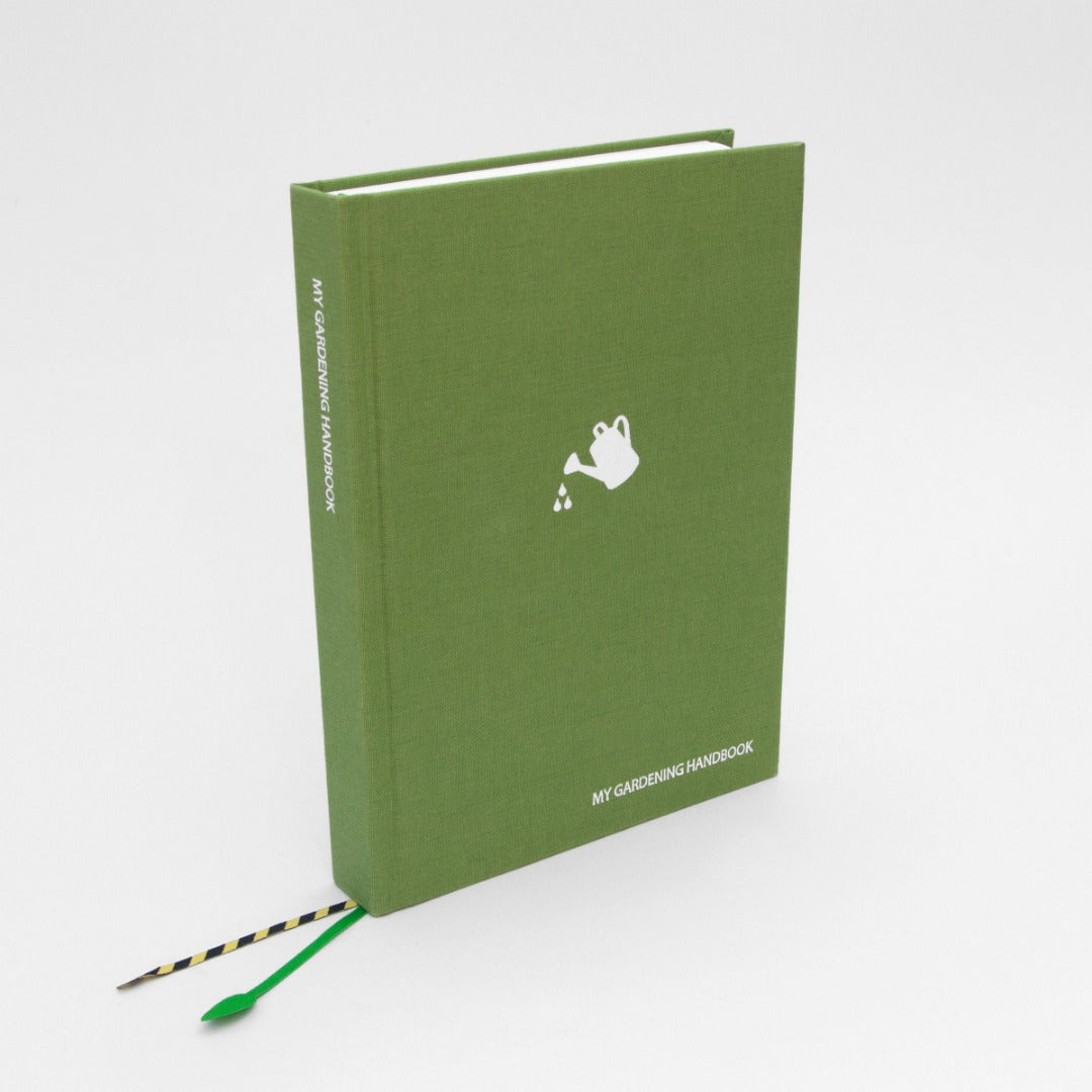 Green cloth notebook with white watering can logo and text reading 'MY GARDENING HANDBOOK' in the bottom right and on the spine.