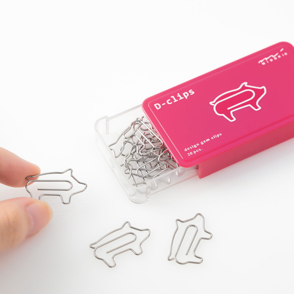 Pig shaped paper clips in slide-open pink box.