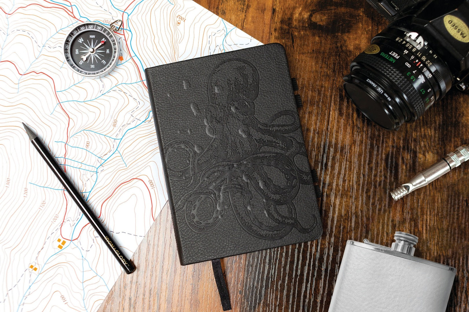 water resistant journal on a table with a map and camera