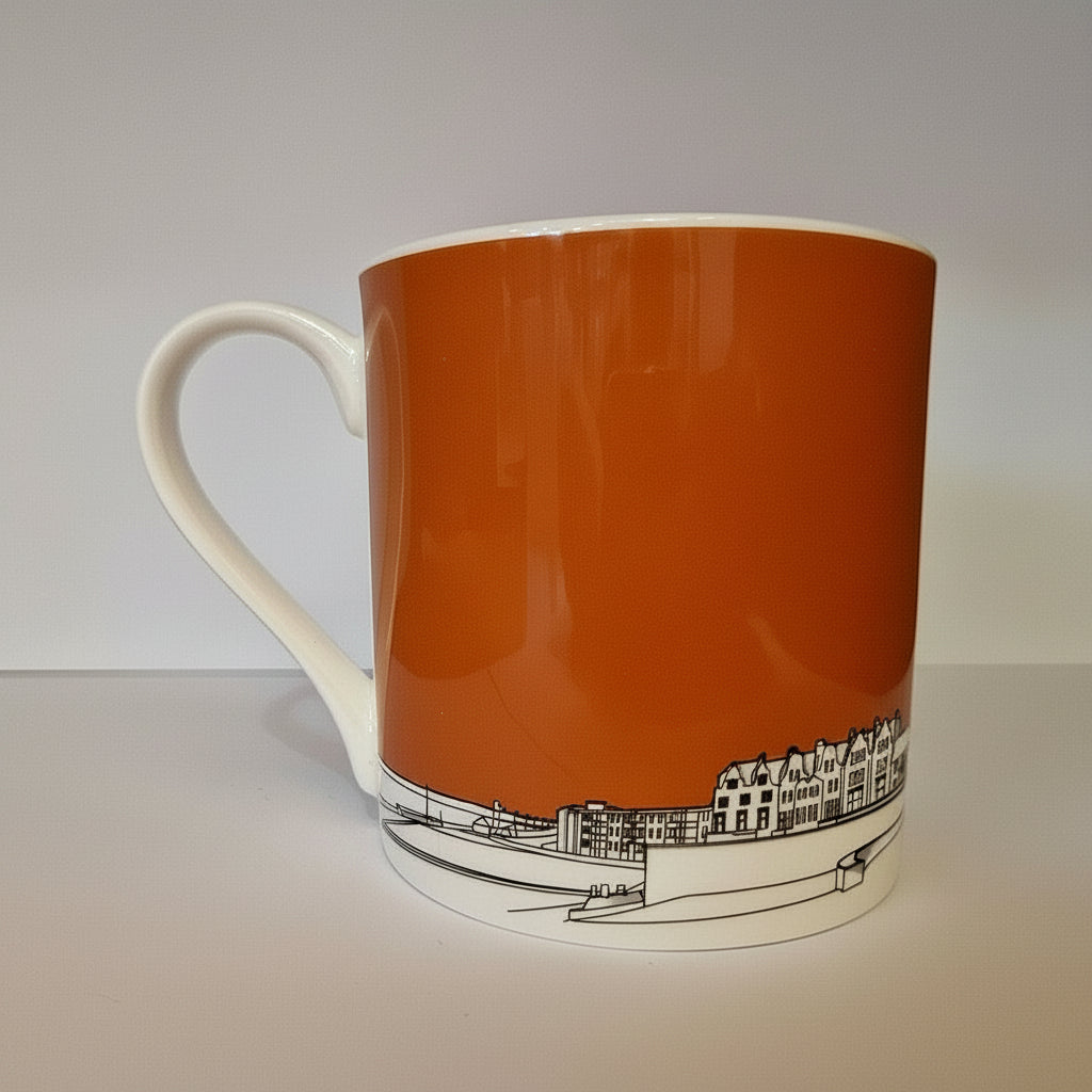 Orange mug with a black and white design on a light gray background