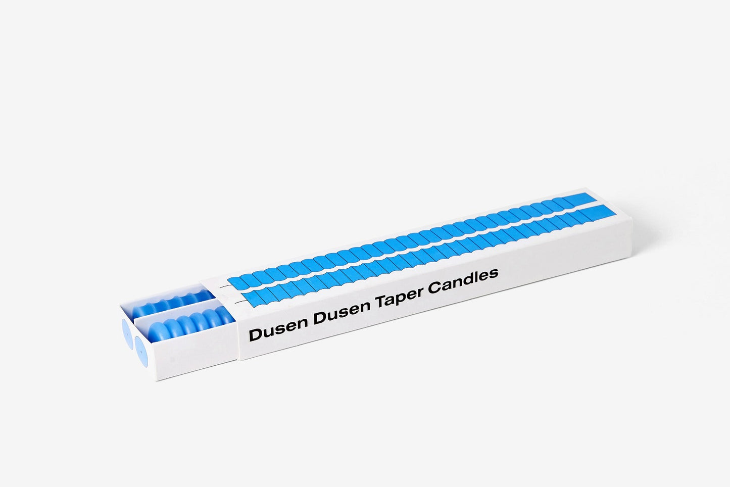 two blue candles in a box with an image of the candles and text reading 'Dunsen Dunsen Taper Candles' - one candle has convex bumps and the other has concave dips.