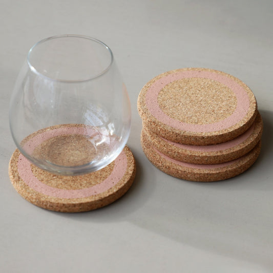 four Earth Cork Coasters in Rose with a glass on one