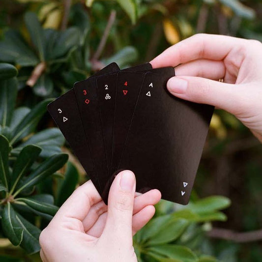 minimalist black playing cards being held