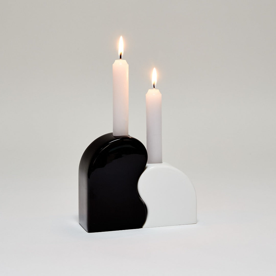 curved black and white candle holders which fit together - two lit white candles are in them