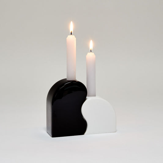 curved black and white candle holders which fit together - two lit white candles are in them