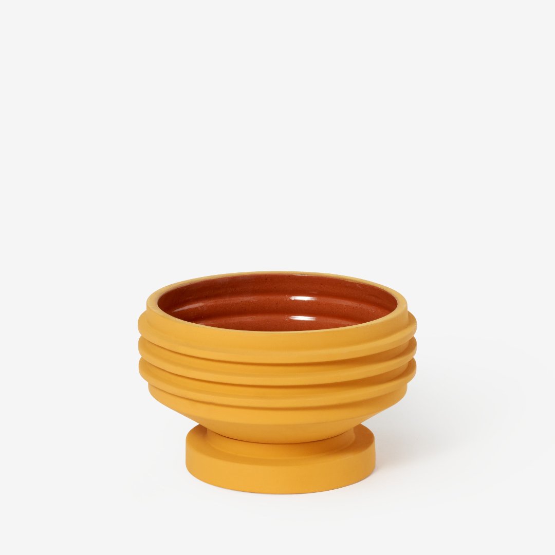 Yellow plant pot with sculptural ridges and shape, and a terracotta glazed inside.