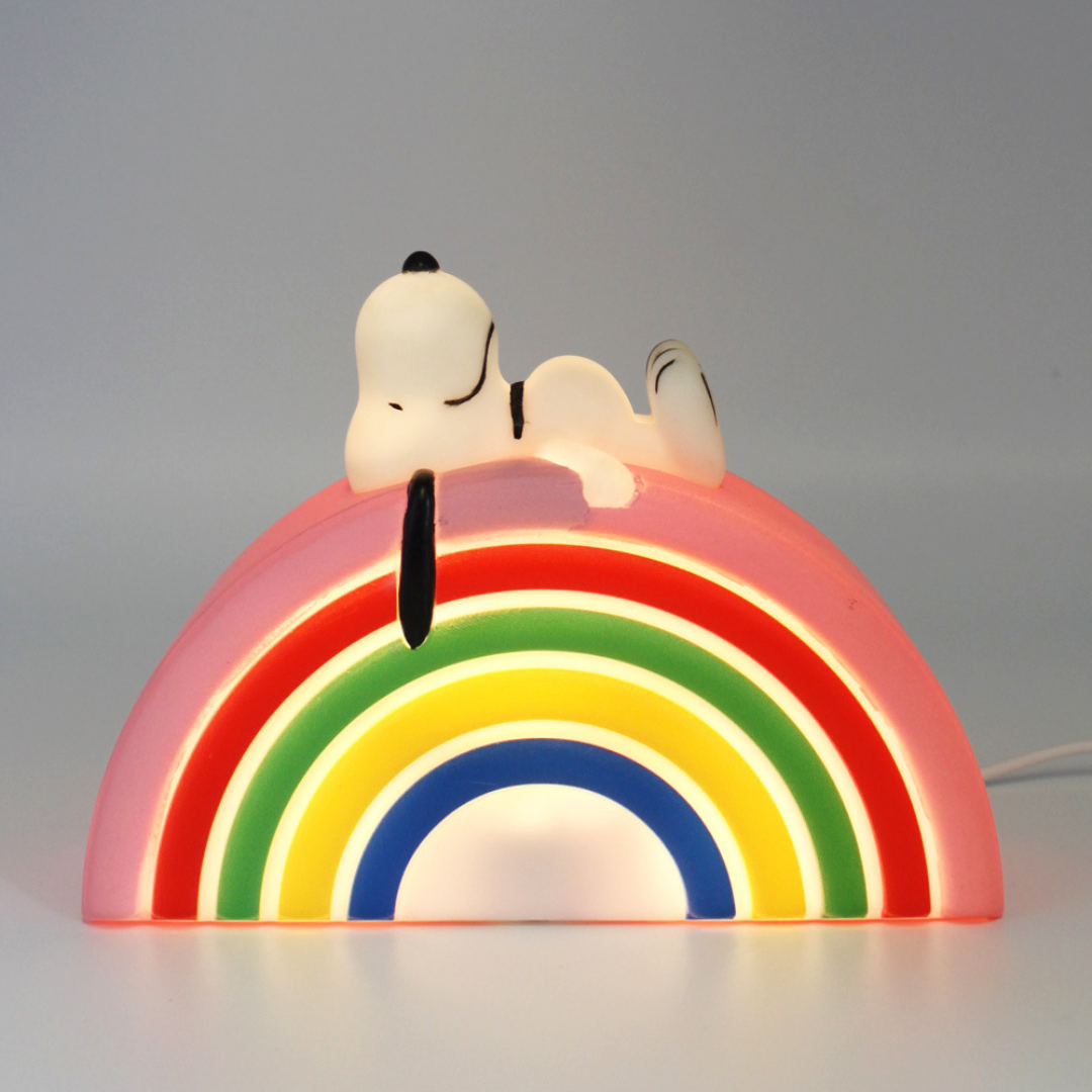 Lamp in the shape of a rainbow, with Snoopy lying on top.
