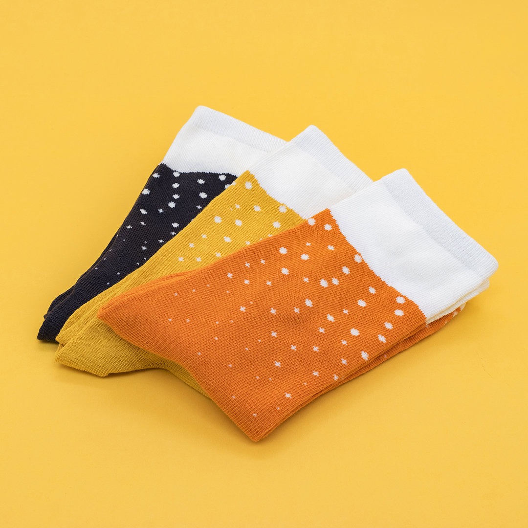 three pairs of socks replicating beer in orange, yellow, and black, with white at the tops.