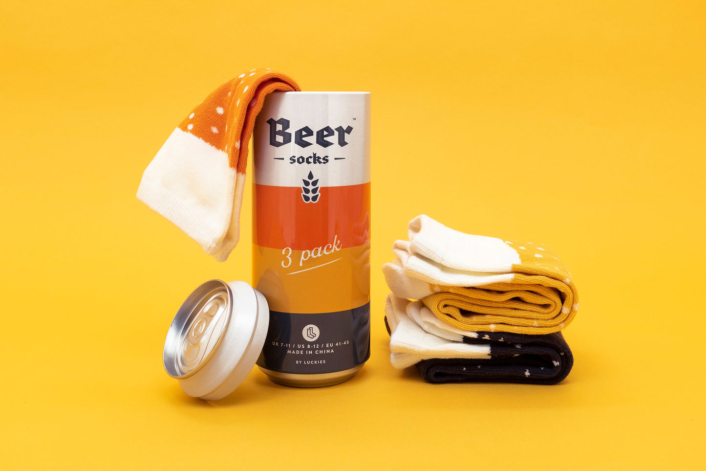 tin shaped like a beer can with three socks replicating beers in three colours